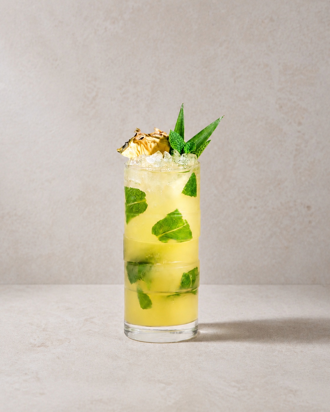 Touchdown served over crushed ice in a highball on warm stone, garnished with pineapple and mint